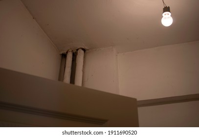 The Cobweb Corner Of A Room's Ceiling And A Lighted Lamp