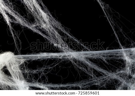 Cobweb or spider's web against a black background, to be used as overlay for Halloween designs