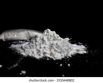 Cocaine drug powder in bag and cocaine powder pile on black background