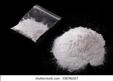 Cocaine in plastic packet on black background, closeup