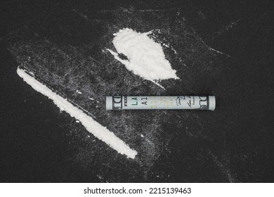 Cocaine With Rolled Dollar On Black Table. A Rolled Up Dollar Bill For Drug Use. Drug Epidemic Concept.
