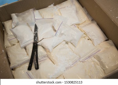 Cocaine warehouse. Close-up plastic bags with cocaine in a box. Illegal drugs traffic.
