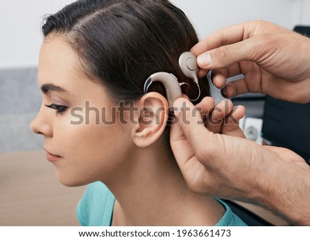Cochlear implant. Installation cochlear implant on woman's ear for restores hearing