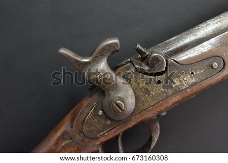 The cocked trigger of a flintlock, part of old-fashioned gun