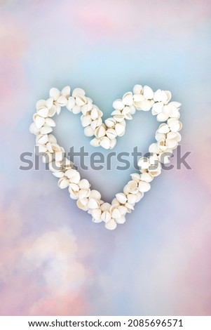 Cockleshell heart shaped seashell wreath on sky cloud background. Symbol of love for Valentines Day, Mothers Day, birthday greeting card. Copy space. Flat lay, top view.