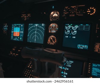 Cockpit view of an airplane during a night-time flight with illuminated instrument panels - Powered by Shutterstock