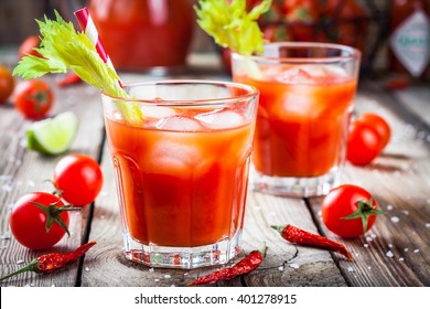 Cocktail Bloody Mary with ice in glasses on a wooden table