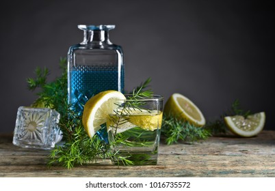 Cocktail with blue gin , tonic and lemon on a old wooden table . 