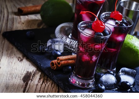 Cocktail with blueberry, cinnamon and lime, black background, selective focus