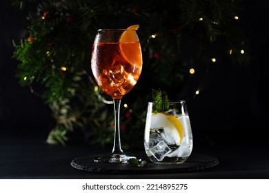 Cocktail called orange spritz and gin tonic or Moscow mule in dark party mood. Celebration scene with dark background. Christmas or New Year Party decoration with candle lights. Happy hour poster. - Powered by Shutterstock