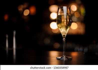 Cocktail With Champagne And A Sugar Cube In The Glass On The Bar Counter In The Dark Blurred Background