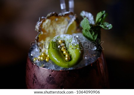 cocktail in a copper glass, copper pineapple, beautiful side dish, on the background of the bar