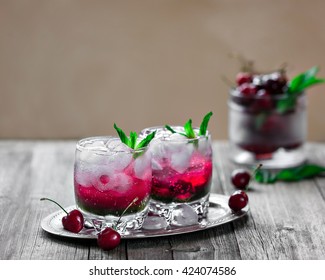 A Cocktail With Gin, Mint Liqueur, Cherry Syrup And Pieces Of Ice On Vintage Background