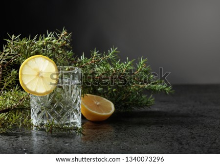 Cocktail gin , tonic with slices of lemon and a sprig of juniper . 