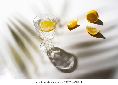 Cocktail Glass  With Lemon On White Background With Palm Tree Shadow 