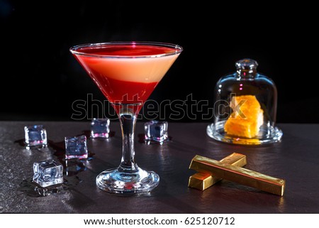 cocktail in glass on a long stalk on the bar black granite
