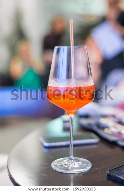 Cocktail in glass\
with tube on restaurant\
table