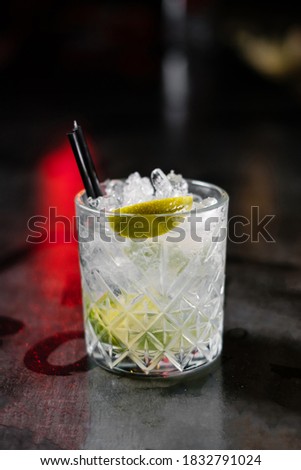 Cocktail with ice and orange liqueur decorated with lime. Making cocktails at home like an expert nightclub barman.