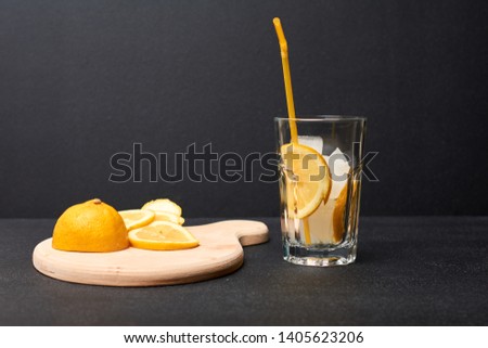 Cocktail with lemon and ice on a dark background. Lemonade. Alcoholic lemon cocktail with ice.