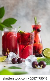 Cocktail or lemonade with cherries and lime, grey stone background. Mocktail. Cold summer drink. - Shutterstock ID 2087475046