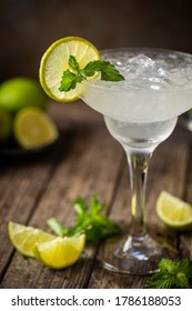 Cocktail margarita garnished with lime and mint on wooden background - Shutterstock ID 1786188053