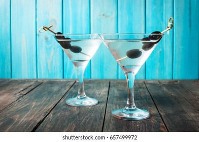Cocktail martini with olives on a wood table