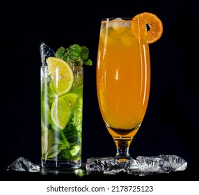 Cocktail Mojito With Ice On Bar Counter In A Restaurant, Pub. Orange Drink, Lime Juice, Mint. Fresh Prepared Alcoholic Cooler Beverage On An Isolated Black Background.