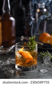 Cocktail Old Fashioned Negroni. The astringency of the whiskey is leveled by sugar, and the herbal tincture and smoking rosemary add flavor and original notes. Served with ice and orange