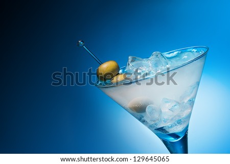 Cocktail with olives on blue background