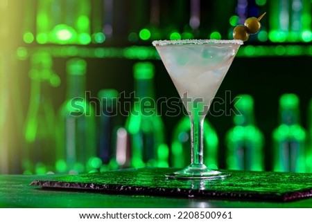 Cocktail on bar counter in a restaurant, pub. Fresh drink. Alcoholic cooler beverage at nightclub on dark background.
