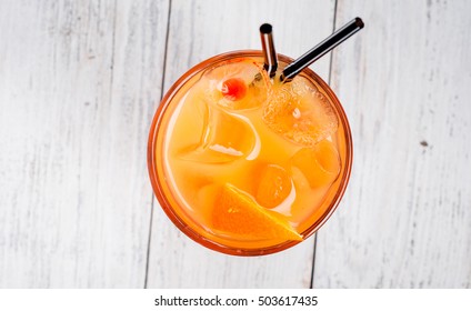 Cocktail With Orange Juice And Ice Cubes On White Background Top View.