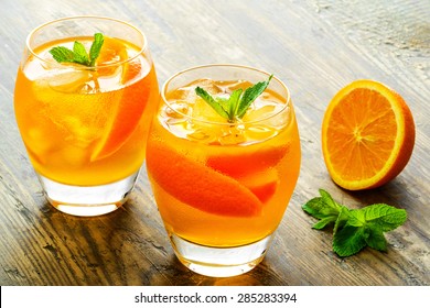 Cocktail. Orange juice with  mint and ice rustic wooden table