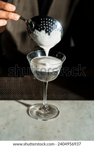 A cocktail is an alcoholic drink mixed with other flavorful drinks or ingredients.  Before being served in a special cocktail glass, the drink is stirred or shaken so that the ingredients are mixed