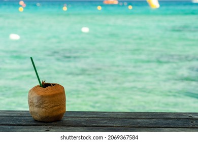 Cocktail in peeled coconut near the crystal blue sea