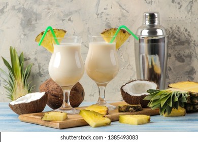Cocktail Pina Colada. Pina Colada refreshing summer alcoholic cocktail with coconut milk and pineapple juice nearby. summer drink. cocktail preparation. on a light background and on a blue table.