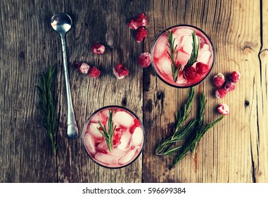 Cocktail-mocktail. Fruity Cocktail Drink Decorated With Frozen Or Fresh Raspberry, Strawberry, Rosemary, Ice And Soda. Domestic Cocktail With Ice And Rosemary