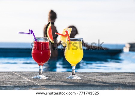 Cocktails and the couple in swimming pool