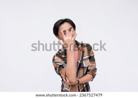 A cocky young man taunting you with a you cant see me gesture with hand. Isolated on a white background.