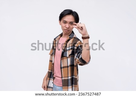 A cocky young man taunting you saying you have a minute chance of beating him. Gesturing with finger and thumb expressing something insignificantly small. Isolated on a white background.