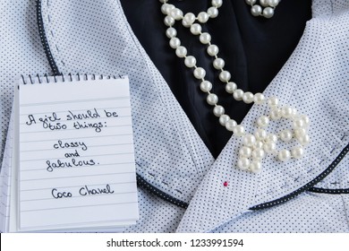 Coco Chanel quotes written on a block note, pearl accessories and a classy jacket ,inspiration phrase 