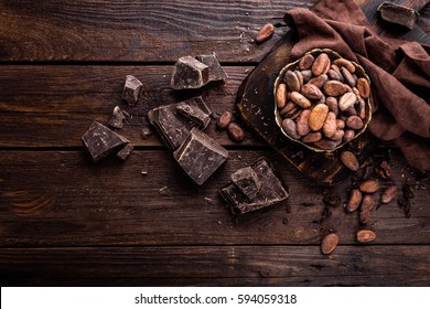 Cocoa Beans And Chocolate On Wooden Background