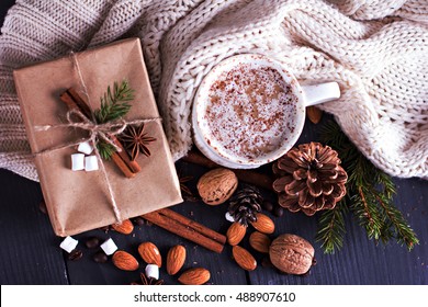 Cocoa, coffee  with marshmallows, fir branch, nuts, gift, cozy knitted blanket. Winter, New Year, Christmas still life. - Powered by Shutterstock