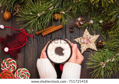 Cocoa with marshmallow in women's hands in the New Year decoration