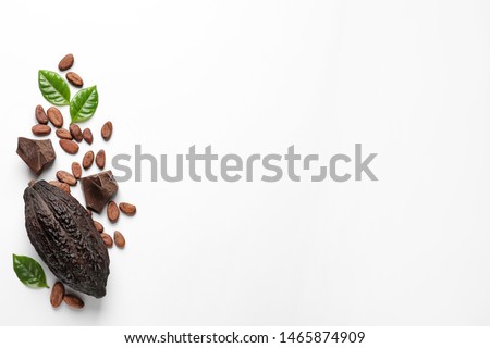 Cocoa pod with beans and chocolate pieces on white background, top view