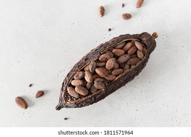 Cocoa pod with cocoa beans on a white concrete background. Organic food. Natural chocolate. Top view. chocolatier, confectionery.