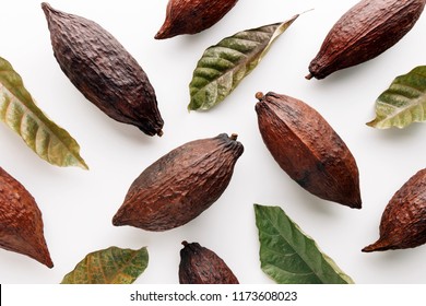 Cocoa pods with cocoa leaves on a white background, creative flat lay food concept