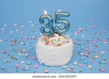  Coconut birthday cake on blue background with burning candles number 35 and many colorful sprinkles. - Powered by Shutterstock