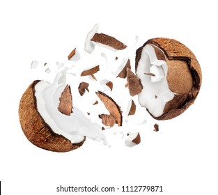 Coconut broken in the air into two halves with milk splashes 