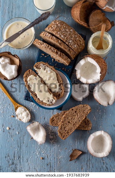 Coconut butter cream spread\
on slices of whole wheat bread with fresh coconut and flakes. Top\
view.