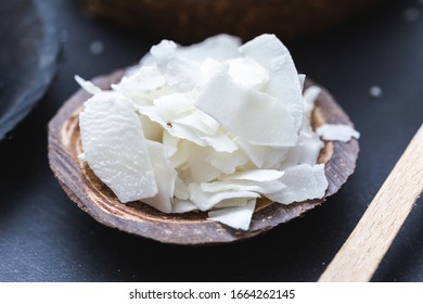 Coconut Chunks On A Coconut Bark Cup On A Dark Table Top.